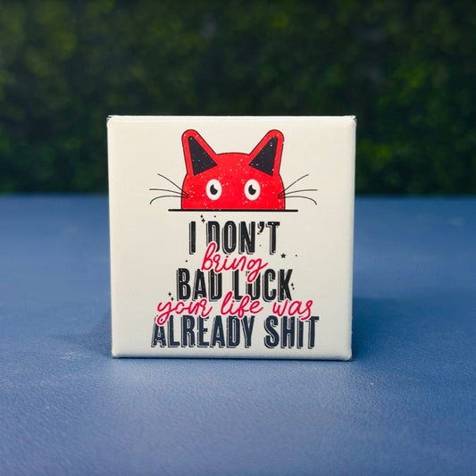 Square cat magnet with a bold red cartoon cat and the phrase “I Don’t Bring Bad Luck, Your Life Was Already Sh*t.” Featuring distressed black and red lettering and a mint green background, this dark humor magnet is perfect for cat lovers with a sarcastic streak. Ideal for fridges, lockers, or as a gag gift for friends who love edgy humor and feline sass.