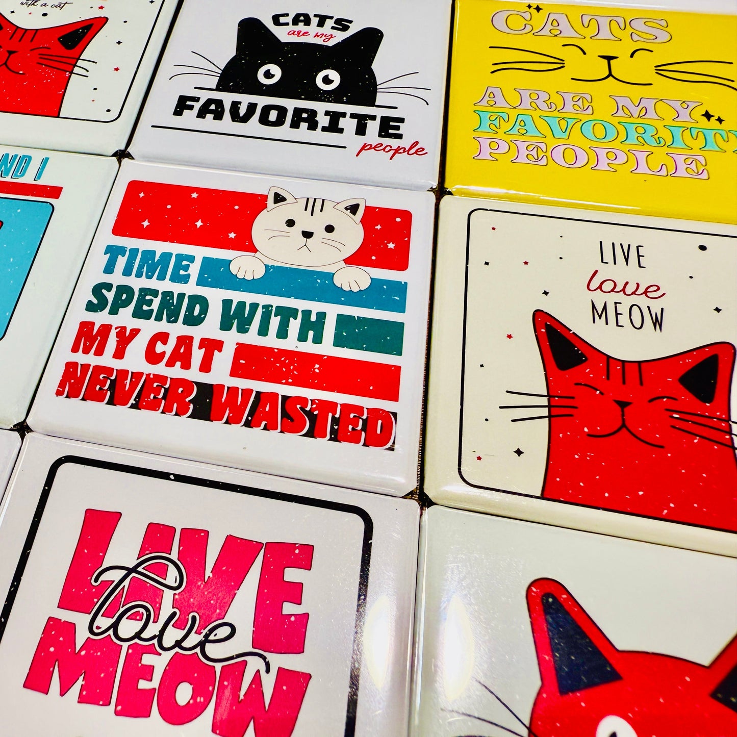 Collection of cat-themed coasters with various designs and text.