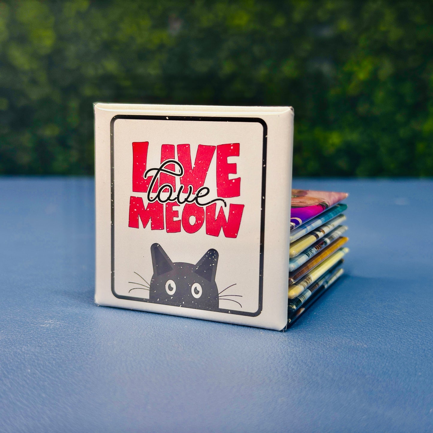 Square cat magnet featuring the phrase “Live Love Meow” in bold pink lettering with a black cartoon cat peeking from the bottom. A cute and funny cat-themed fridge magnet perfect for cat lovers, pet owners, and anyone who loves playful feline decor. Great as a gift for cat moms, stocking stuffer, or whimsical kitchen accessory. Ideal for fridges, lockers, or office magnet boards.