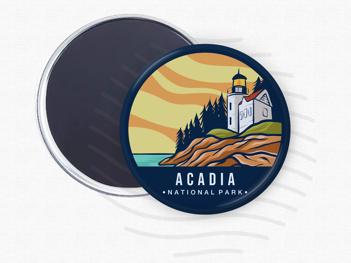 Acadia National Park magnet – 2.5” round fridge magnet featuring a colorful illustration of a lighthouse on rocky cliffs with evergreen trees and a sunset sky. Strong magnetic back shown. Ideal souvenir or gift for national park lovers and travelers.