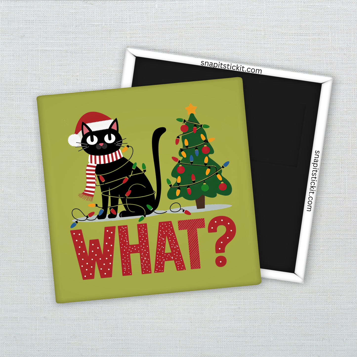Black cat in a Santa hat and scarf wrapped in Christmas lights, sitting next to a tangled holiday tree. Text below reads: “WHAT?” Humorous 2x2 holiday magnet.