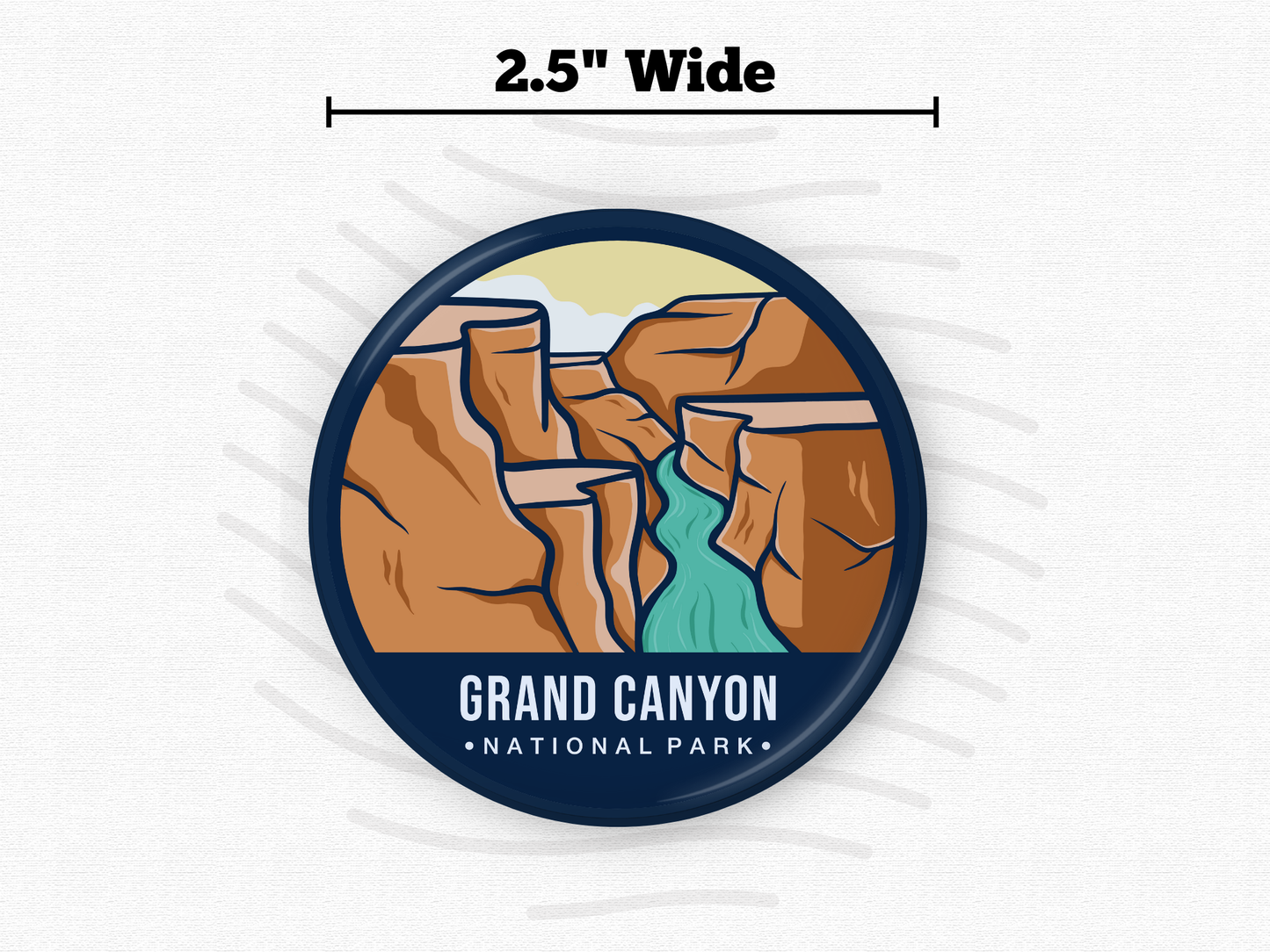 Round magnet of Grand Canyon National Park depicting layered red rock canyons with a turquoise river winding through the center under a light sky.