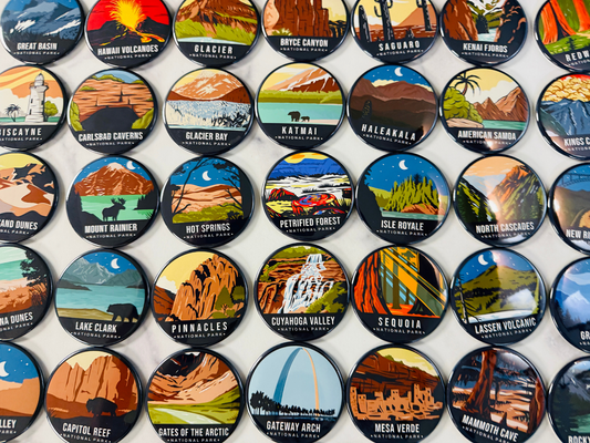 Collection of round National Park magnets displayed on a white surface – colorful 2.5” magnets featuring stylized illustrations and names of parks including Yellowstone, Glacier, Zion, Haleakalā, Acadia, Bryce Canyon, and more. Ideal for travelers, collectors, and outdoor enthusiasts looking for unique fridge decor or national park souvenirs.