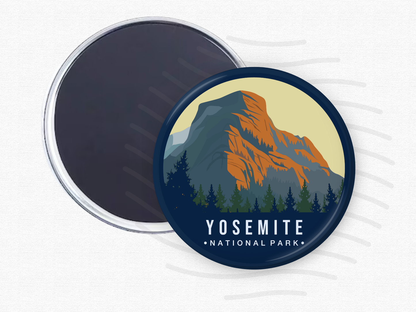 Round magnet of Yosemite National Park showcasing a majestic granite mountain with orange and blue hues, framed by dense evergreen trees under a soft beige sky.