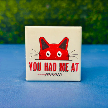 Square magnet featuring a red cartoon cat peeking over a line with the phrase “You Had Me at Meow” in bold retro text. Set on a soft green background, this whimsical magnet is perfect for fridges, lockers, or office spaces. A heartfelt gift for cat lovers, couples, or anyone smitten with their furry feline companion.