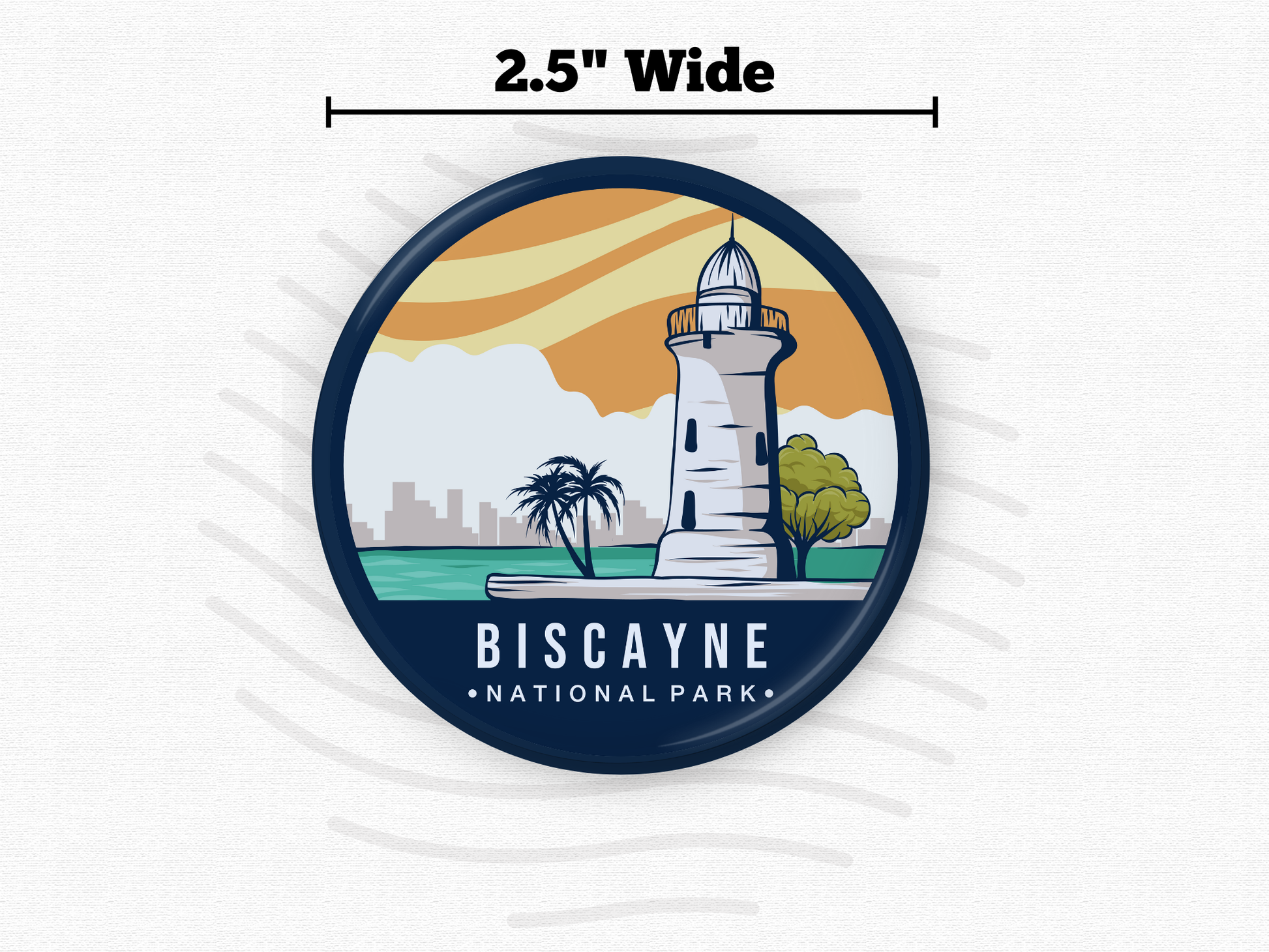 “Round magnet featuring Biscayne National Park with a coastal lighthouse, palm trees, and city skyline under a golden sunset sky.”