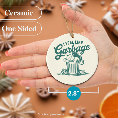 Ceramic Christmas ornament with a cat graphic and text held in a hand, surrounded by decorative items.