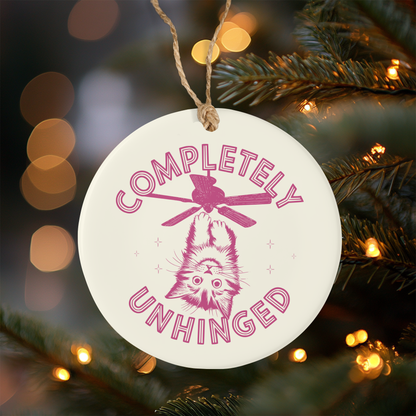 Ceramic Christmas Ornament with 'Completely Unhinged' text and cat illustration on a Christmas tree.
