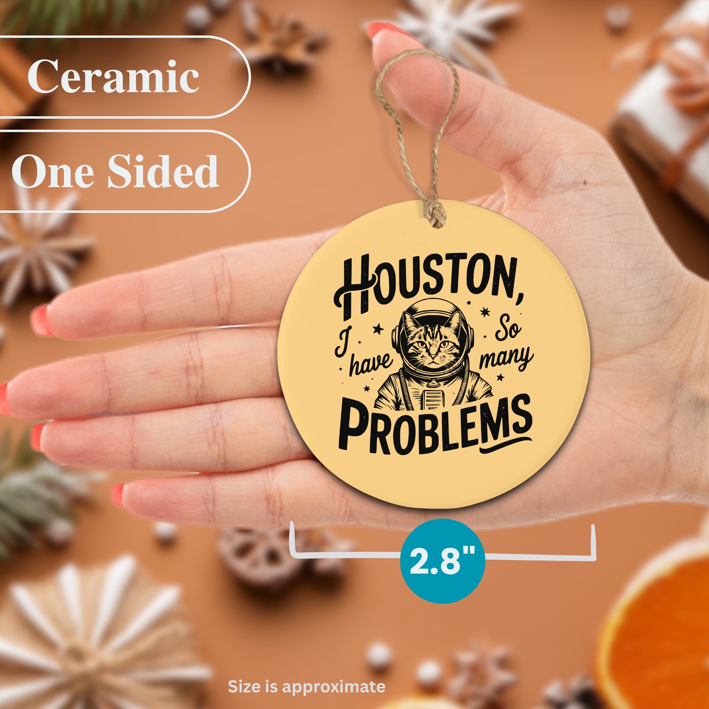 Round ceramic ornament with 'Houston, I have so many problems' text held in a hand against a decorative background.