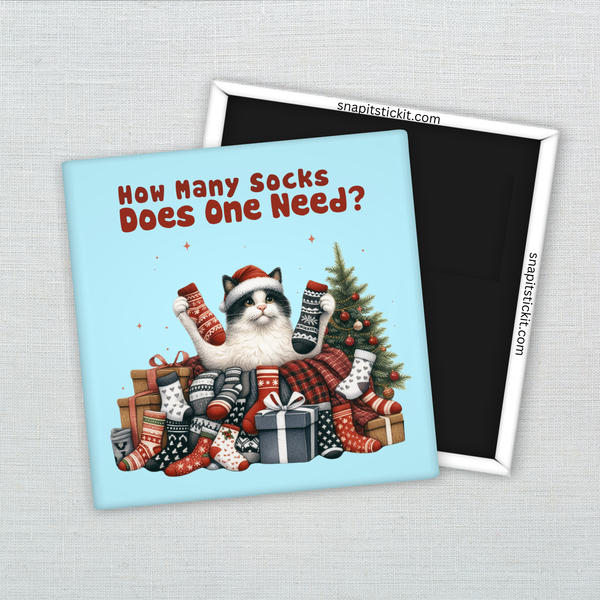 Black-and-white cat wearing a Santa hat surrounded by a pile of holiday socks and gifts. Holding up two more socks under the text: “How many socks does one need?” Funny 2x2 holiday magnet.
