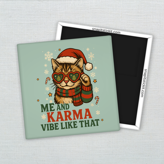 Striped cat in Santa hat and heart-shaped sunglasses with scarf, surrounded by snowflakes and candy canes. Text reads “Me and Karma Vibe Like That.” Funny 2x2 holiday magnet.