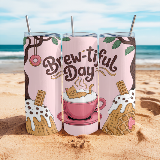 Three tumblers with 'Brew-tiful Day' design on a beach.