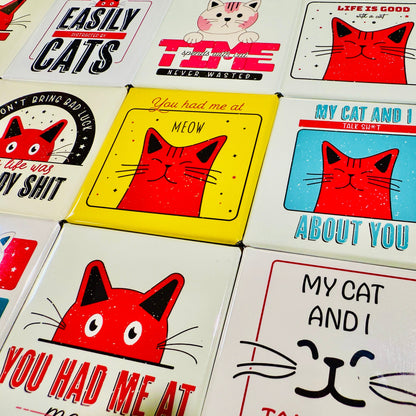 Collection of cat-themed magnets with various designs and text.
