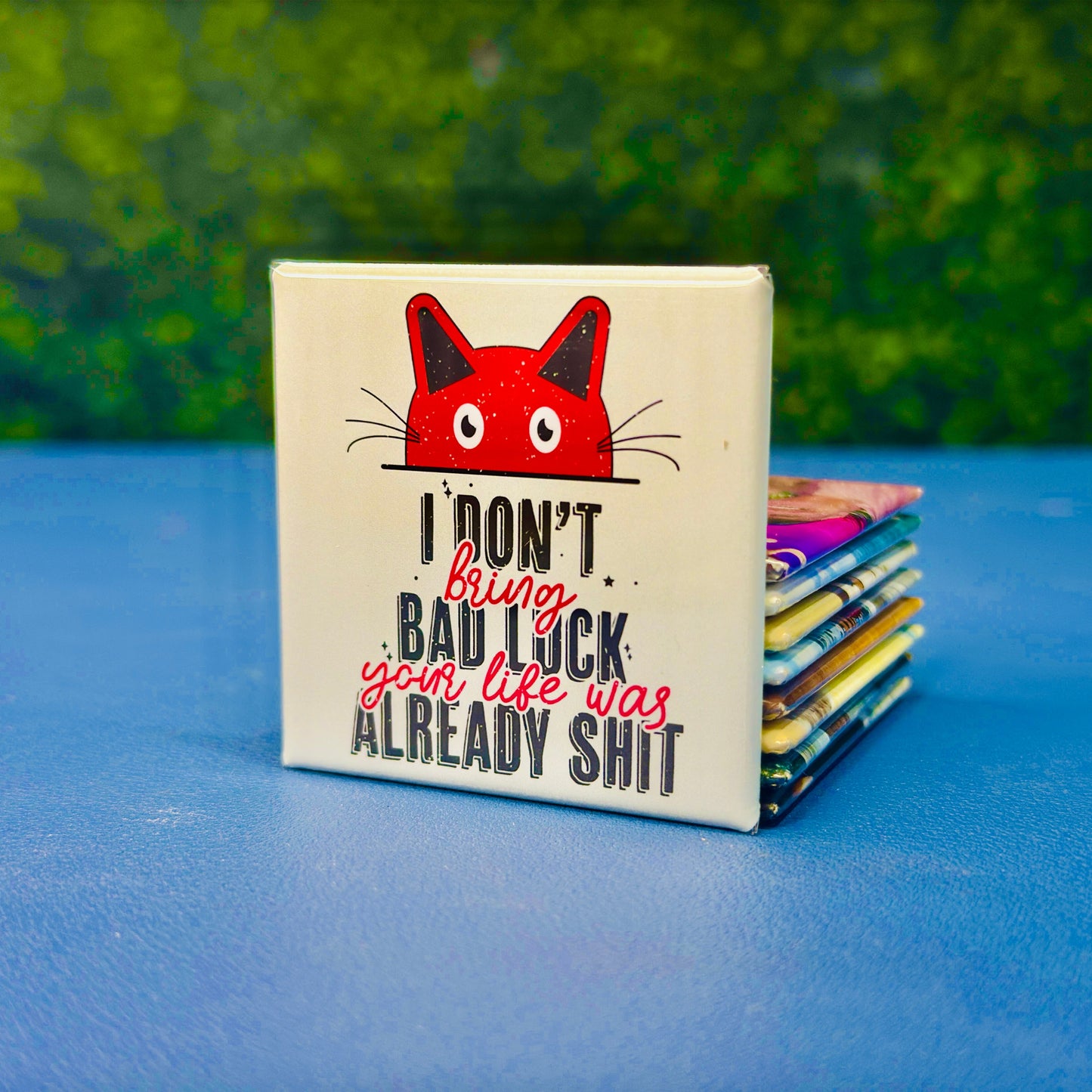 Square cat magnet with a bold red cartoon cat and the phrase “I Don’t Bring Bad Luck, Your Life Was Already Sh*t.” Featuring distressed black and red lettering and a mint green background, this dark humor magnet is perfect for cat lovers with a sarcastic streak. Ideal for fridges, lockers, or as a gag gift for friends who love edgy humor and feline sass.