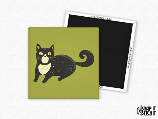 Cute black cat fridge magnet – 2x2” square magnet featuring a smiling cartoon black cat with yellow eyes, curly tail, and cream chest patch on a green background. Strong magnetic back with Snap It Stick It branding. Fun gift for cat lovers, Halloween fans, or quirky decor.