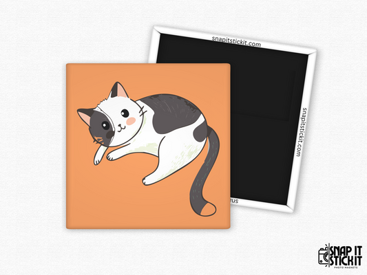 Adorable lounging cat fridge magnet – 2x2” square magnet with a kawaii-style black and white cartoon cat laying down playfully on an orange background. Features a strong magnetic back with Snap It Stick It branding. Perfect gift for cat lovers, pet parents, and fans of cute kitchen decor.