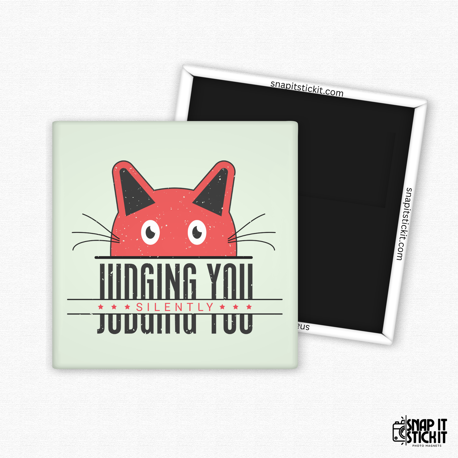 Fridge magnet with a red cat face design and text on a light green background