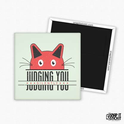 Fridge magnet with a red cat face design and text on a light green background