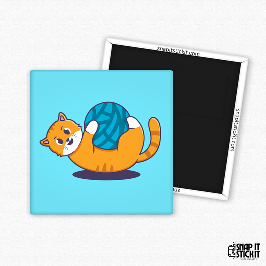 Fridge magnet with a cartoon cat holding a ball of yarn on a blue background