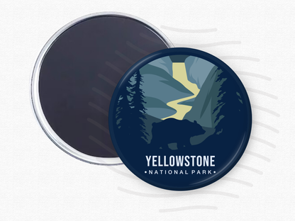 ound magnet of Yellowstone National Park featuring a silhouette of a bear in the foreground, a winding yellow river, and dark blue evergreen trees set against towering canyon walls.